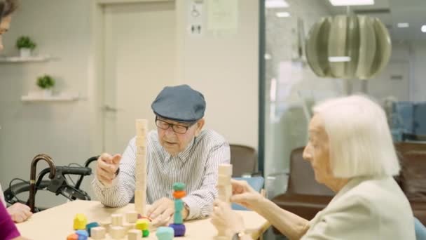 Video of a man building a wooden tower as skill games in a geriatric - Footage, Video