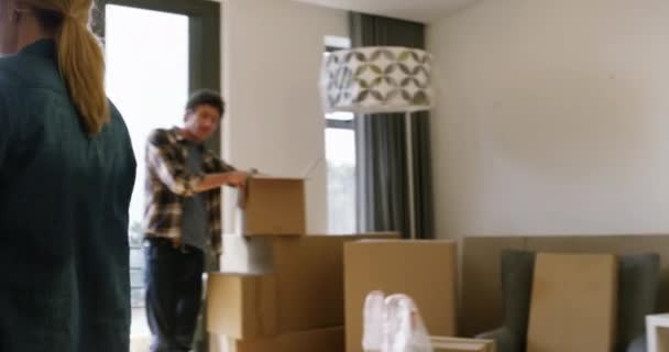 Happy couple, box and hug for new house, interior or apartment in real estate together. Man and woman hugging with boxes for property, investment or relocation and renovation in buying success. - Footage, Video