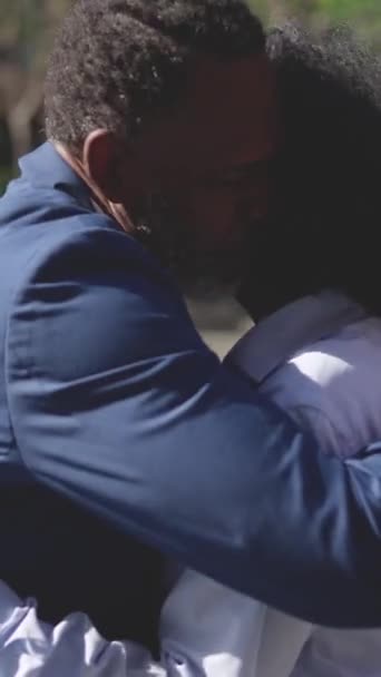 Video van zwarte zakenman knuffelen en geven twee kussen aan een collega in een outdoor ontmoetingsplaats - Video