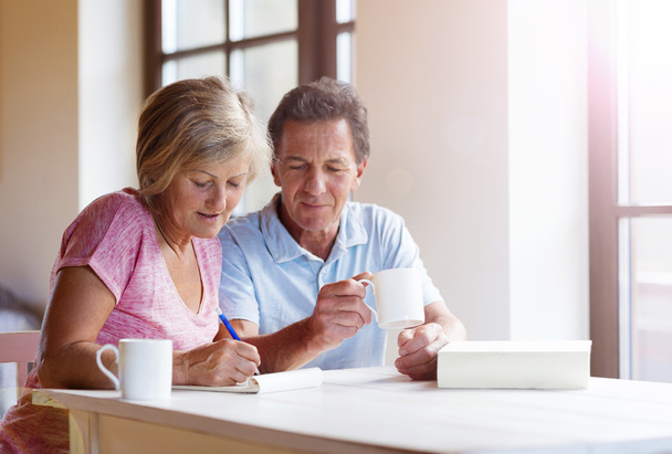 Senior couple making plans and drinking coffee - Foto, Imagen