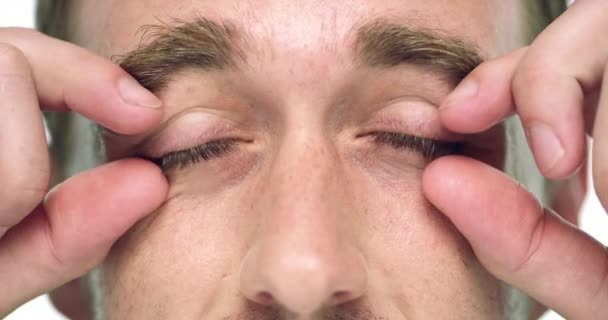 Hands, open eyelid and face for man, tired and check vision for health, wellness or retina exam. Person, eyes and stretching for test, fatigue and burnout with fingers, skin or blue pupil for eyeball. - Felvétel, videó