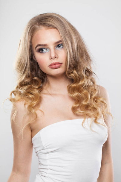 Krása módní portrét krásné blondýny s dlouhými vlnitými vlasy, make-up a čistou pleť na bílém pozadí - Fotografie, Obrázek
