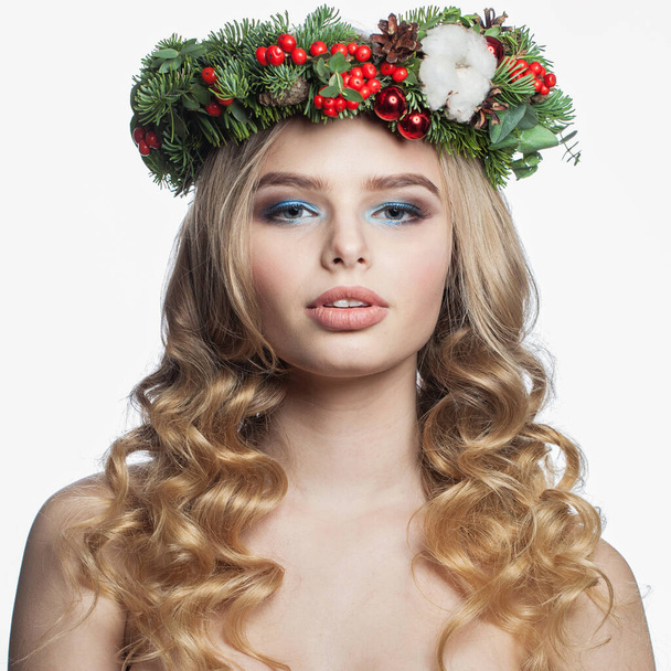 Attractive healthy young woman with party makeup, long blonde curly hairdo and Christmas decor isolated on white background. Christmas beauty - Foto, imagen