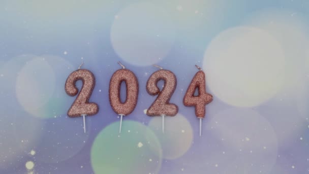 Velas brillantes festivas número 2024 se encuentran en un fondo de color lila pastel con borrosa bokeh, plano de primer plano con zoom en. - Metraje, vídeo