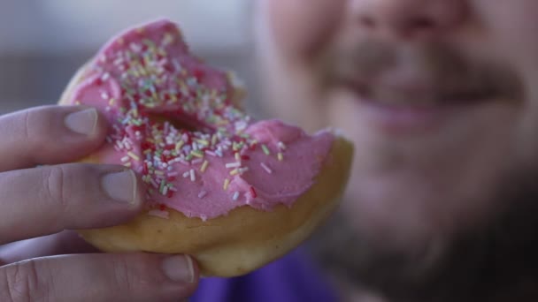 Primer plano de la persona gorda mano sosteniendo donut. Alimentos con carbohidratos de azúcar - Imágenes, Vídeo