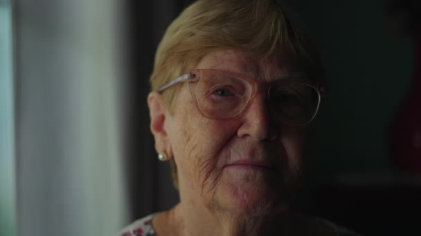 Idős idős nő közelkép arc nézi kamera komoly kifejezés, drámai világítás idősebb nő a 80-as években ábrázoló idős kor és tapasztalat - Felvétel, videó