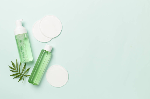 Limpiador facial espumoso y agua micelar con almohadillas ecológicas sobre fondo de color, vista superior - Foto, Imagen