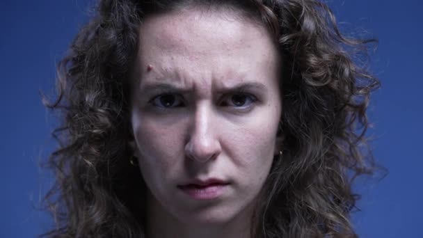 Αναστατωμένη γυναίκα κατσουφιάζει τα φρύδια με σοβαρή έκφραση κοιτάζοντας απευθείας στην κάμερα - Πλάνα, βίντεο