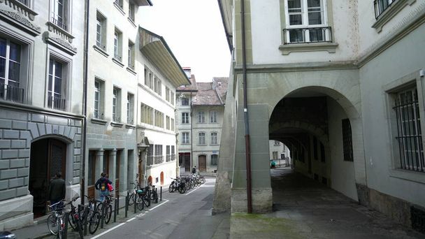 Fribourg, İsviçre Circa Mart 2022 - Antika mimari binaları ve park edilmiş bisikletleri olan boş geleneksel Avrupa caddesi - Fotoğraf, Görsel