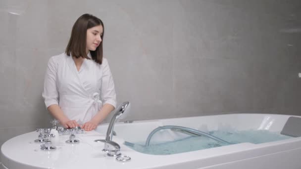 Spécialiste spa femme près du bain à remous. Hydromassage professionnel. - Séquence, vidéo