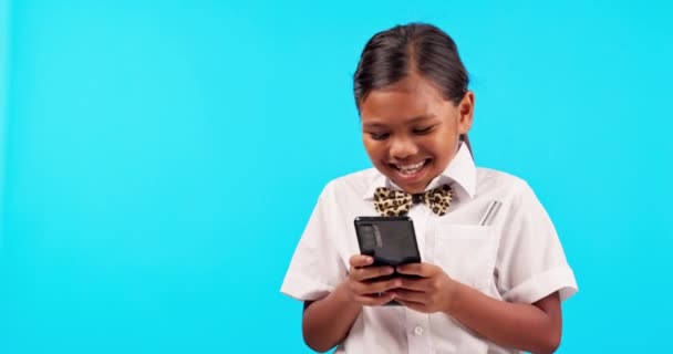 Mockup, kind en meisje met een smartphone, grappige en sociale media tegen een blauwe studio achtergrond. Vrouwelijk kind, model en peuter met een mobiele telefoon, mobiele app en lachen met verbinding en typen. - Video