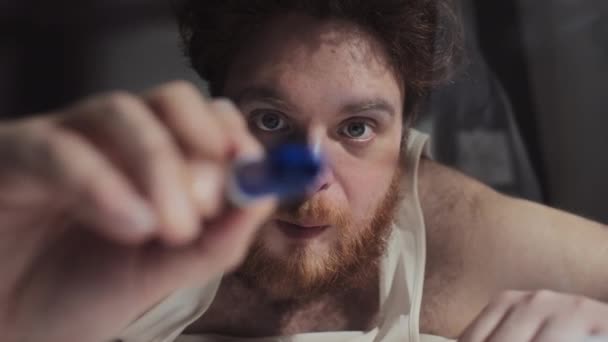 Detailní portrét muže s mentální poruchou kreslí něco na okenní sklo s modrým značkovacím perem - Záběry, video