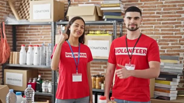Activistas confiados, hombres y mujeres, voluntarios en el centro de caridad, de pie juntos, dando un gesto pulgar hacia arriba en la unidad - Metraje, vídeo