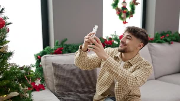 Fiatal arab férfi, hogy fényképet karácsonyfa otthon - Felvétel, videó