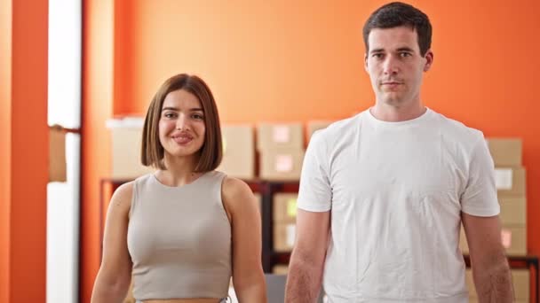 Dwóch robotników mężczyzna i kobieta stojący razem z rękami skrzyżowani gestem uśmiechający się do biura - Materiał filmowy, wideo