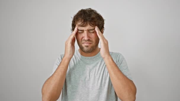 Stressaantunut nuori mies t-paidassa kiinni pään kipu, kärsivät migreeni vastaan eristetty valkoinen tausta. - Materiaali, video