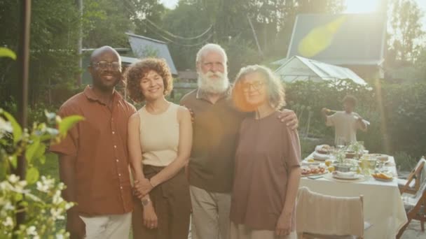 Średni długi portret rodzinny starszego mężczyzny i kobiety razem z córką i jej mężem stojących na podwórku uśmiechniętych do kamery - Materiał filmowy, wideo