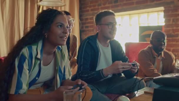 Etnik çeşitliliğe sahip bir grup arkadaş retro konsol oyunu oynamaktan zevk alıyor, beyaz adam kazanıyor. - Video, Çekim