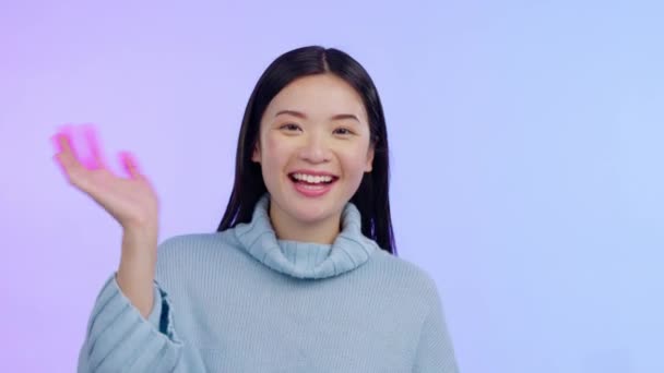 Videogesprek, portret van Aziatische vrouw zwaaien hand en tegen een studio achtergrond voor welkomstgebaar. Communicatie of hallo contact, begroeting of introductie en vrouwelijke persoon met emoji teken - Video
