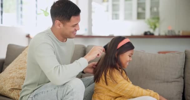Lány, apa és kefe haj gondossággal, támogatás és kötődés apa minőségi időt együtt kanapén, kanapén vagy nappaliban. Gyermekem, segíts a hajápolásban és a reggeli beszélgetésben a lányoddal és a szüleiddel.. - Felvétel, videó