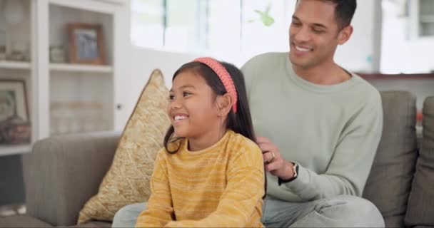 Apa, lány és kefe haj gondossággal, támogatás és kötődés apával minőségi időt együtt kanapén, kanapén vagy nappaliban. Gyermek, hajápolás és reggeli beszélgetés a családdal a házban. - Felvétel, videó