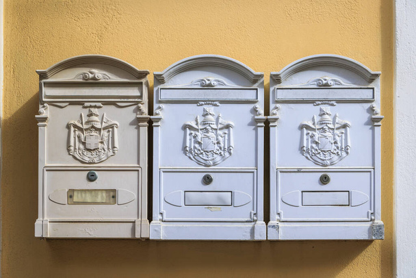 Drie witte brievenbussen op een gele muur in de stad Corfu op het eiland Corfu - Foto, afbeelding