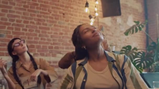 Gioiosa giovane donna afroamericana che balla alla musica durante la festa con i compagni abusivi in casa abbandonata - Filmati, video