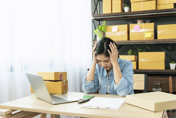 Mulher asiática desesperada estresse dor de cabeça deprimido a partir de startup pequeno negócio em casa escritório. Uma mulher de negócios falhada trabalha em casa. Empreendedor vendedor on-line tem problema de entrega trabalho infeliz - Foto, Imagem