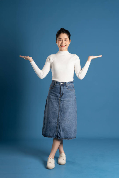 Kuva kaunis aasialainen nainen poseeraa sinisellä taustalla - Valokuva, kuva