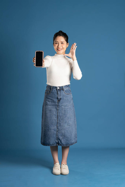 Image of beautiful Asian woman posing on blue background - Fotó, kép