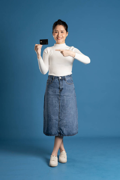 Imagen de una hermosa mujer asiática posando sobre fondo azul - Foto, imagen