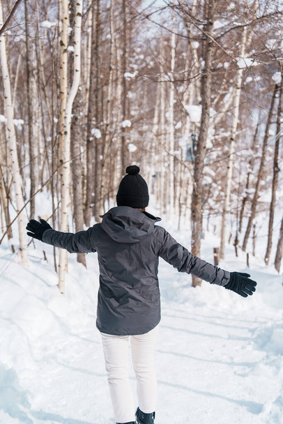 雪に覆われた森を歩くスイーターと幸せな旅行者. ウィンタートラベル,アドベンチャー,探検,バケーションのコンセプト - 写真・画像