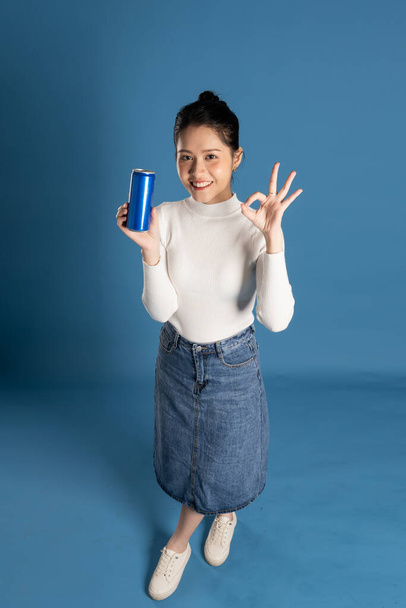 Portrait of beautiful asian girl posing on blue background - Photo, Image
