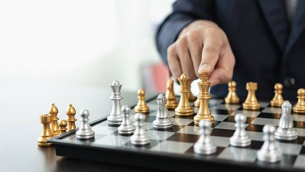 Um homem de negócios inteligente joga um jogo de xadrez com a equipe adversária. Planeje estratégias de negócios para desenvolver a vitória e o sucesso. Dificuldade e meta Alcançar Estratégia de negócio para a vitória - Foto, Imagem