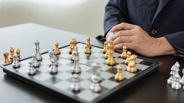Ένας έξυπνος επιχειρηματίας παίζει σκάκι με την αντίπαλη ομάδα. Σχεδιάστε επιχειρηματικές στρατηγικές για την ανάπτυξη για τη νίκη και την επιτυχία. Δυσκολία και επίτευξη στόχου Επιχειρηματική στρατηγική για τη νίκη - Φωτογραφία, εικόνα