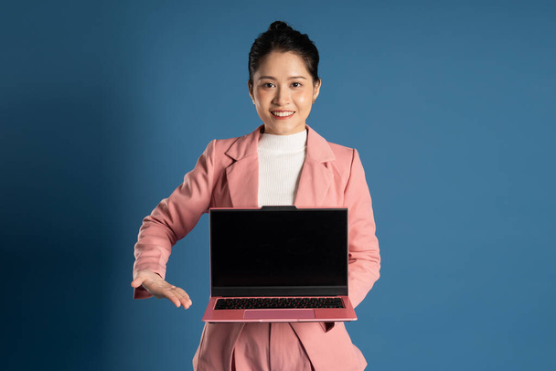 Portrait de jeune femme d'affaires asiatique posant isolée sur fond bleu - Photo, image