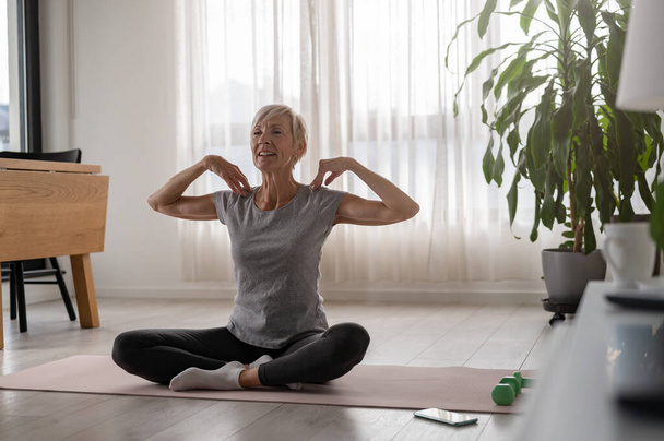 Активна старша жінка практикує йогу в приміщенні - Фото, зображення