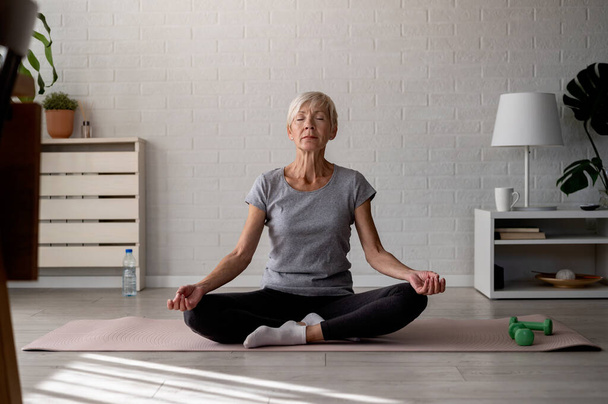 Aktywna seniorka ćwicząca jogę w pomieszczeniach - Zdjęcie, obraz