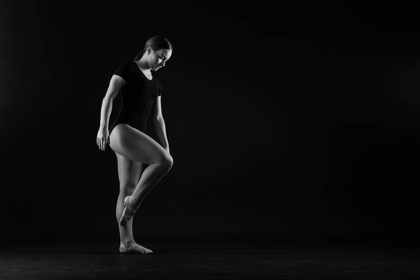 Gimnastyka, kobieta akrobatka, gimnastyczka silna elastyczna budowa ciała na czarno-białym tle - Zdjęcie, obraz