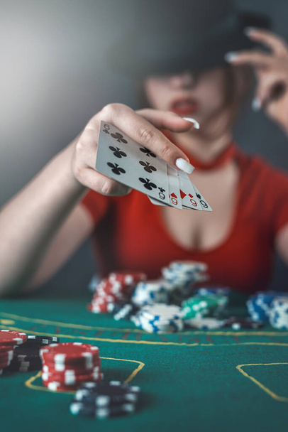 poker player sits at a poker table with cards in her hands and poker chips on the table. poker. casino - Fotó, kép