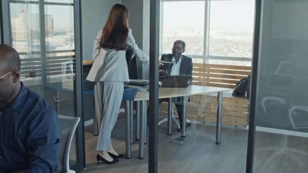 Hosszú lassított felvétel a női alkalmazottakról, amint belépnek az igazgatói irodába, és átadják a jelentést a főnöknek, aki felülvizsgálja és visszaadja. - Felvétel, videó