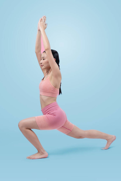Femme asiatique en vêtements de sport faisant de l'exercice de yoga en position debout sur la forme physique comme sa routine d'entraînement d'entraînement. Soins du corps sains et mode de vie de yoga de méditation en plan complet sur fond isolé. Vigoureux - Photo, image