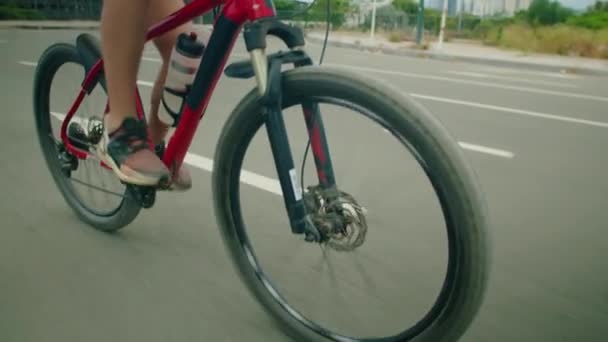 Tiener zoon en vader in sportkleding en helmen rijden fietsen op asfalt weg tijdens het reizen in de stad op zomerdag - Video