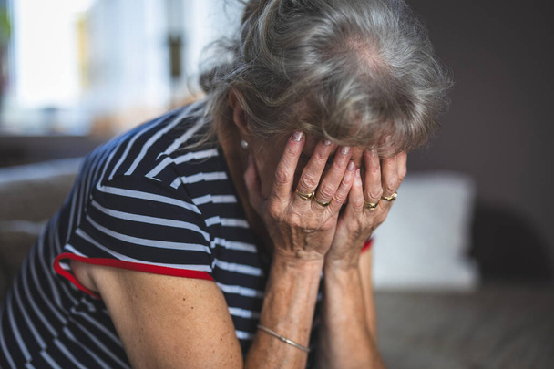 Пригнічена старша жінка покрила обличчя обома руками - Фото, зображення