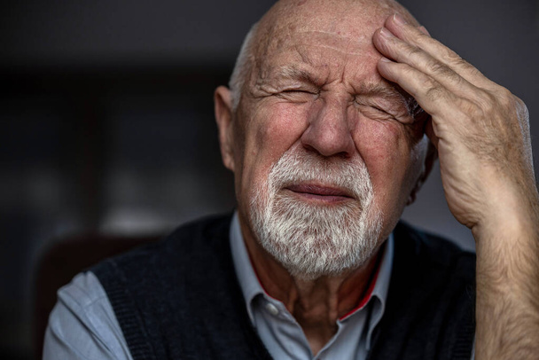 Porträt eines älteren Mannes, der unter Kopfschmerzen leidet  - Foto, Bild