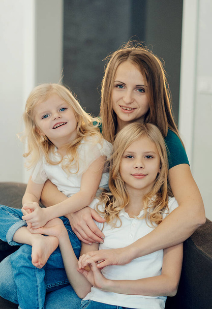 family at home having fun. mother and daughters laughing on the sofa - Photo, Image