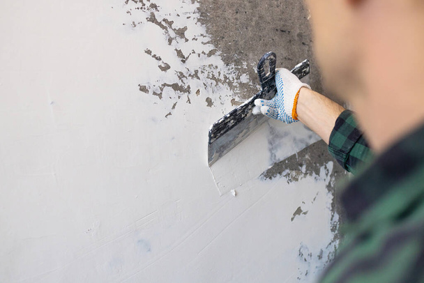 Χέρια άνθρωπος σοβατζής οικοδόμος στην εργασία με σπάτουλα, σοβάς έναν τοίχο, closeup. - Φωτογραφία, εικόνα