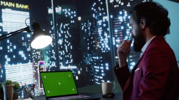 Багатий бізнесмен оглядає зелений колір на ноутбуці, захоплюючись видом на центр міста зі свого офісного столу. Професійний виконавчий директор, що працює за кілька годин з порожнім шаблоном макета копій. - Кадри, відео