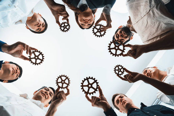 El equipo empresarial que se une a cogwheel en forma circular simboliza el exitoso grupo de asociaciones empresariales y el fuerte trabajo en equipo de unidad colectiva en el lugar de trabajo comunitario con eficiencia productiva. Prudente - Foto, imagen