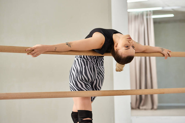 woman perfects dance choreography, showcasing her strength and grace as she leans on bar - Photo, Image